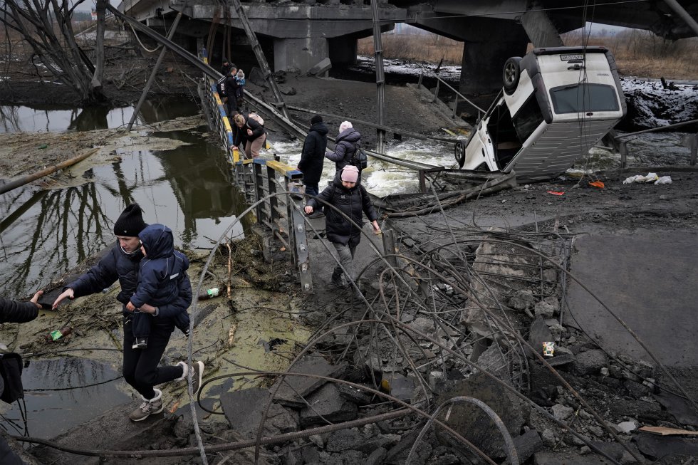 Puente sobre el río Irpin, a una veintena de kilómetros del centro de Kiev, volado el viernes 25 de febrero por el ejército ucranio para tratar de evitar la llegada de tropas rusas a la capital. Los civiles cruzan sobre los escombros en una y otra dirección para tratar de llegar a la estación de trenes en Kiev. 