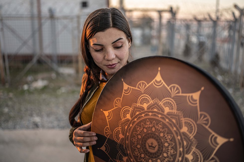 Rana huyó de su pueblo junto a su familia atrás la llegada del Estado Islámico y encontraron refugio en el campo de personas desplazadas de Kankhe. Es una joven que encontró en la música una forma de sanar las heridas provocadas por las perdidas y procesar la vida día a día en un limbo como lo es un campo de desplazados.