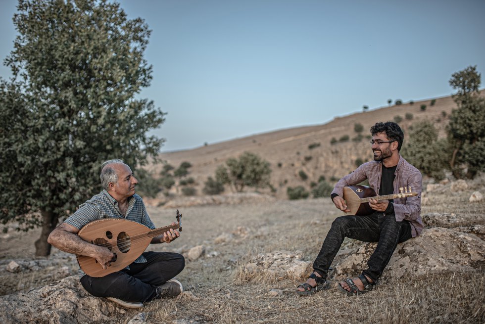 Fahad y Gani Mirzo junto a la higuera donde se refugio con su familia durante 12 días hasta la llegada de los kurdos sirios que conformaron un corredor humanitario que les permito bajar de las montañas. ha montado una escuela en Sinjar para los niños y niñas yazidíes retornados. Un espacio seguro para procesar el dolor y sanar las heridas de la guerra a través de la música.