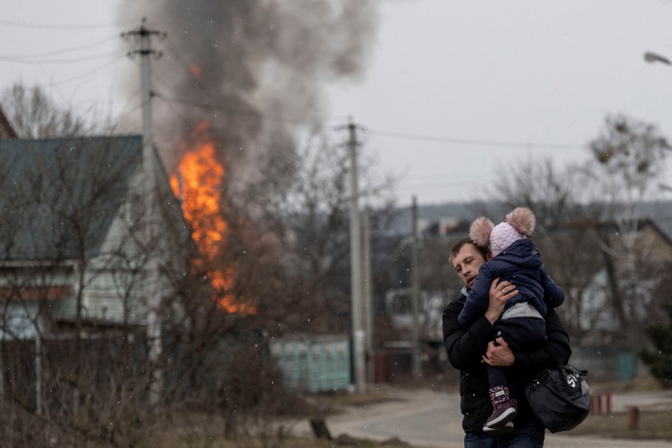 Un hombre escapa junto a un niño de la localidad de Irpin, cerca de Kiev, este domingo.