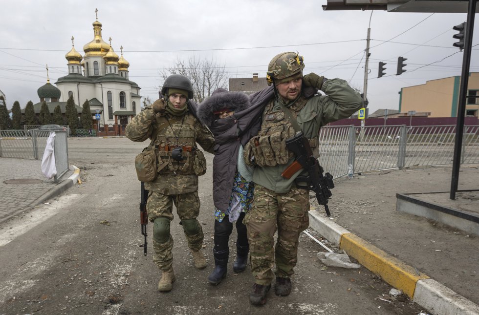 Militares ucranios ayudan a una mujer herida en Irpin, cerca de Kiev.