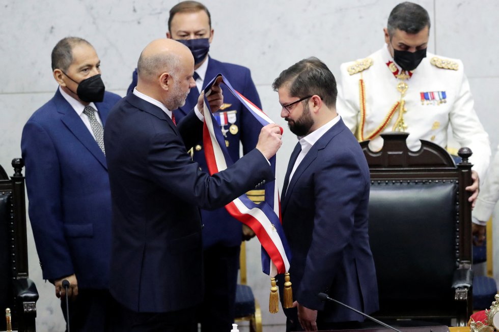 El presidente del senado, Álvaro Elizalde, entrega la banda presidencial a Gabriel Boric.