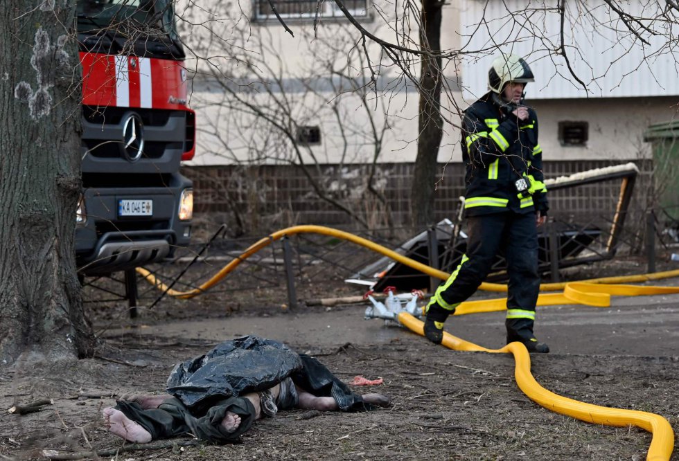 Un bombero pasa junto a una víctima de un ataque ruso en una zona residencial de la capital ucrania, este martes. Mientras arrecian los ataques rusos contra zonas residenciales en Kiev, tres jefes de Gobierno de países de la UE ―Polonia, República Checa y Eslovenia― se dirigen en tren a la capital ucrania, en la primera visita a la ciudad de dirigentes internacionales desde el inicio de la ofensiva rusa hace casi tres semanas. Varsovia ha puesto en marcha la iniciativa a pesar de no contar con el respaldo de la UE y de que el presidente del Consejo Europeo, Charles Michel, advirtió de los riesgos de seguridad que implicaba el viaje, según indican fuentes comunitarias en Bruselas.