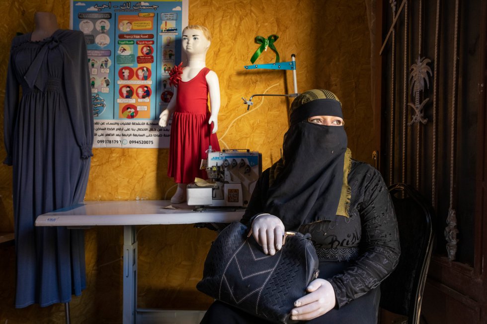 Aisha* (nombre ficticio) en el espacio seguro para mujeres y niñas al acabar su clase de costura. Cuando se sienta ante la máquina de coser, el mundo entero desaparece por un rato, explica. Lo último que ha terminado ha sido un vestido de niña. Le gusta ir también por el ambiente tranquilo y bonito.rn