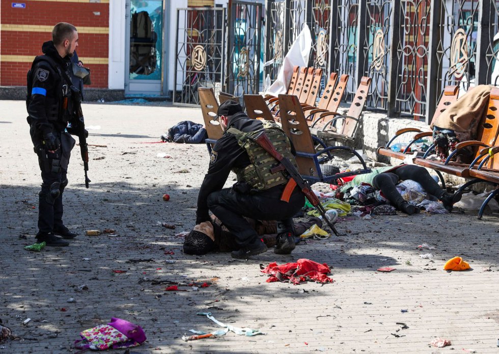 Agentes de policía, junto al cadáver de una mujer en la estación de Kramatorsk, en la región de Donetsk, en el este de Ucrania. Decenas de personas han muerto y cerca de un centenar han resultado heridas este viernes en un ataque de Rusia con un misil a las instalaciones, repletas de civiles que intentaban trasladarse en tren a zonas más seguras del país, según ha informado la compañía ferroviaria estatal ucrania.