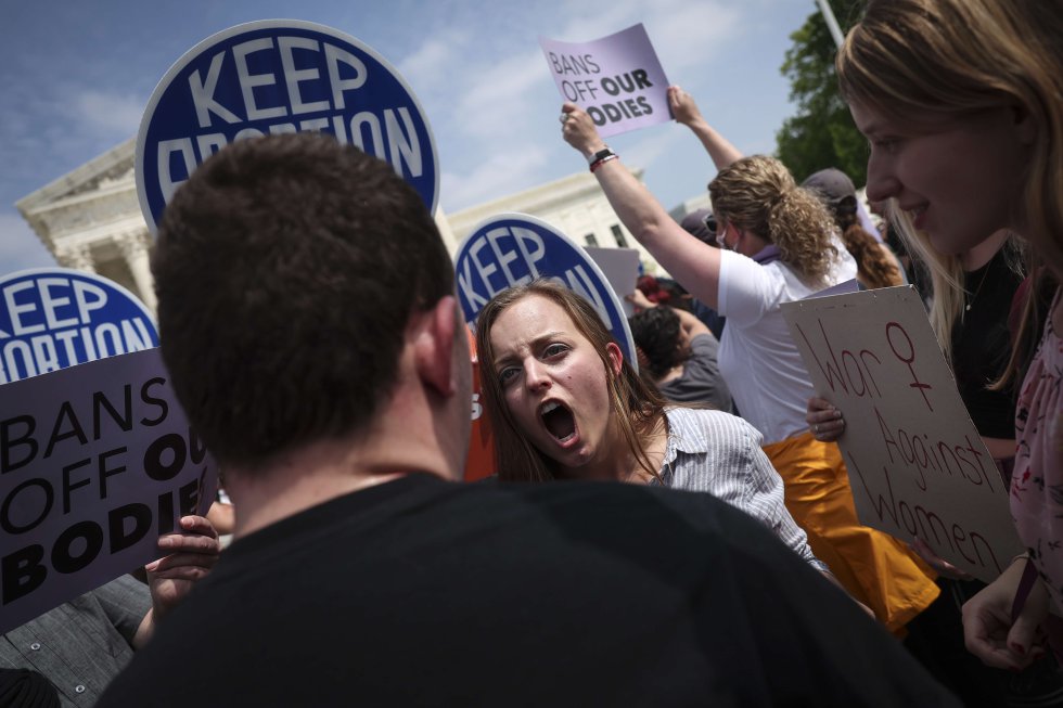 Dos manifestantes con distintas posturas se enfrentan verbalmente.