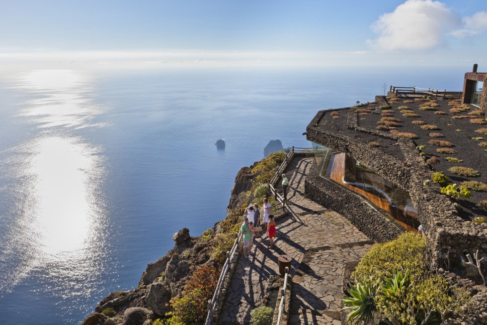 El mirador de La Peña, en Guarazoca, al norte de  la isla canaria de El Hierro , es otro espacio orgánico de César Manrique, con un restaurante en su interior. De puertas hacia afuera permite al visitante comprobar “las consecuencias del gigantesco deslizamiento de tierras que hace milenios creó el valle de El Golfo”, explican desde Turismo de Canarias. Los riscos de esta enorme mella de 15 kilómetros de ancho por uno y medio de alto están cubiertos de una densa vegetación autóctona y, a sus pies, una llanura volcánica de viñedos y frutales que termina en el Atlántico. A lo lejos, los roques de Salmor, santuario de lagartos gigantes endémicos.