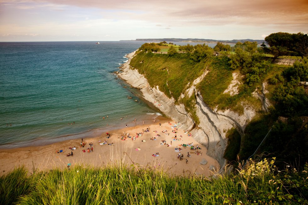 Pocos sospecharían, si les transportaran con los ojos cerrados, que se hallan en Santander. Mataleñas se esconde en la agreste simplicidad de varios acantilados por cuyo derrumbadero se enhebran helechos, tamarindos, plumeros, algún pino disperso. La bella configuración montañosa de Mataleñas y la fina arena dorada son lo más destacado de esta cala de Santander. Diversos miradores compensan a los que se niegan a cubrir los 157 escalones, ese duro peaje que criba a los bañistas (hubo hasta un proyecto de ascensor). Entre los atractivos que la definen figuran además su limpieza contrastada, la seguridad de un oleaje que rompe en el acantilado, convirtiéndose en una piscina en la pleamar. No hay jornada de playa que se precie sin la ración de rabas en el café bar El Faro. Acceso: aparcar entre los cabos Menor y Mayor, junto al campo de golf. Es buena idea llegar por la senda costera que parte del Sardinero.