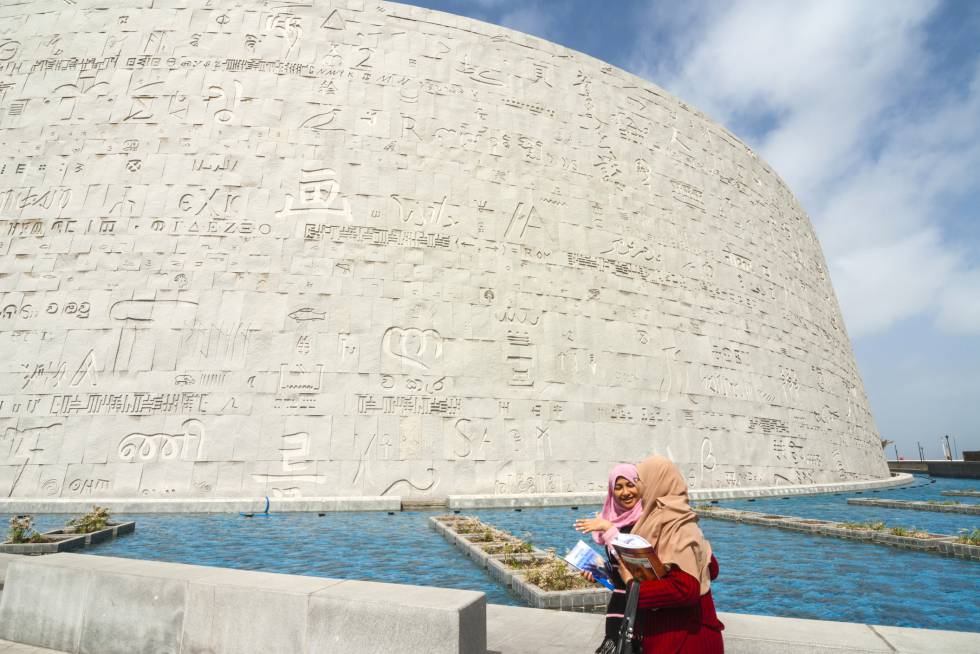 A versão século XXI da legendária Biblioteca de Alexandria, da que mal sobraram vestígios, é um bloque de 11 níveis (quatro deles subterrâneos) e com coberta circular em homenagem a Ra, deus do Sol; vidro e alumínio misturados com o cimento para refletir a luz mediterrânea, em lembrança do legendário farol de Alexandria. Uns 6.400 painéis de granito mostram caracteres de todos os alfabetos conhecidos do planeta em sua fachada (na foto). Foi oficialmente inaugurada em 2002, um milênio e meio após sua antecessora, perto do local que provavelmente ocupava a para recuperar seu “espírito de abertura e erudição”, nas palavras de seus responsáveis. bibalex.org