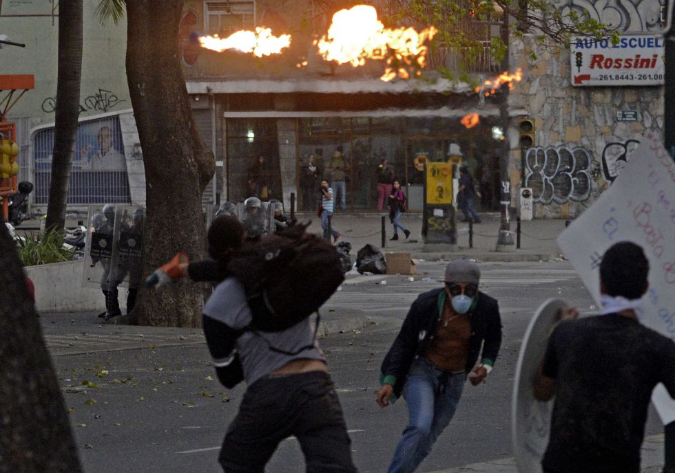 Activistas antigubernamentales se enfrentan a la policía durante las protestas contra el gobierno de Maduro, en Caracas.